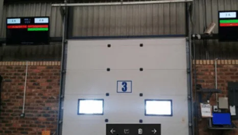 A numbered loading bay door with display screens mounted on either side