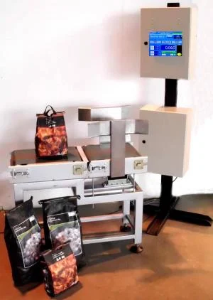 A weighing conveyor with a control panel on a stand and bags of product